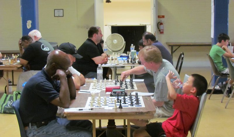 A young player facing an adult across the board