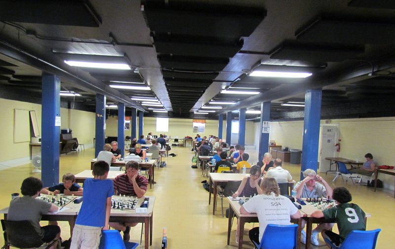 A long hall filled with tables at a club tournament